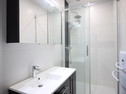 une salle de bain blanche avec un lavabo et une douche dans l'établissement Appartement Neuf 6 Couchages, Terrasse, Parking, WiFi - FR-1-415-67, à Le Mont-Dore