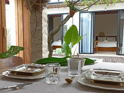 una mesa con platos y vasos encima en Villa Juanjo Sanur, en Sanur