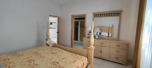 a bedroom with a bed and a dresser and a mirror at Vista al mar live in La Puntica de Juan Dolio