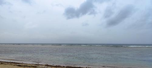 a beach with the ocean on a cloudy day at Vista al mar live in La Puntica de Juan Dolio
