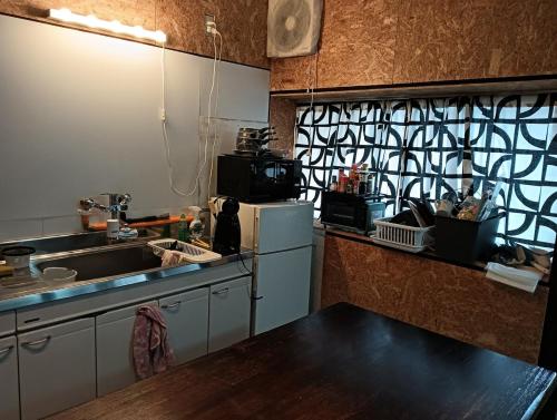 a kitchen with a sink and a counter top at Jupiter 糸島市1棟貸し一長期滞在送迎無料 in Itoshima