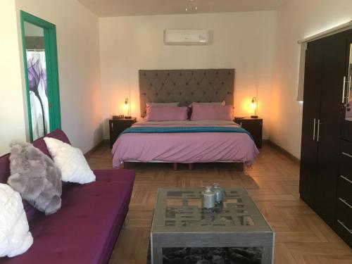 una camera da letto con un letto grande e un divano di loft rosy a Puerto Peñasco