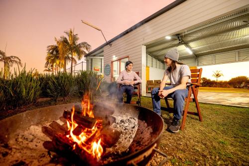 two people sitting in chairs around a fire pit at BIG4 Big River Holiday Park in Seelands
