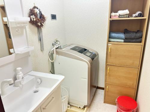 a bathroom with a sink and a washing machine at KASUMI-an 杏 in Kumamoto