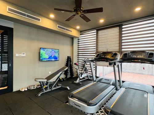 a gym with two tread machines and a ceiling fan at Hotel du Monde Art in Hanoi