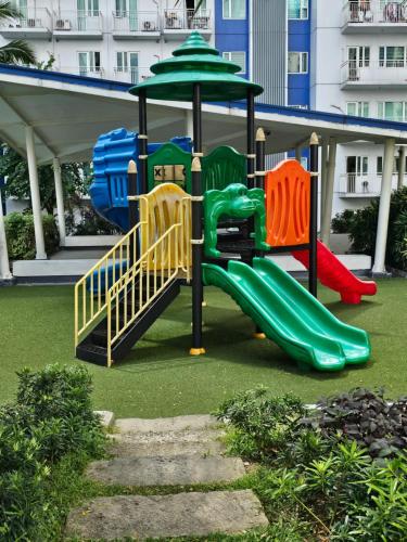 a playground with a slide and an umbrella at Stay at Love Grass in Manila