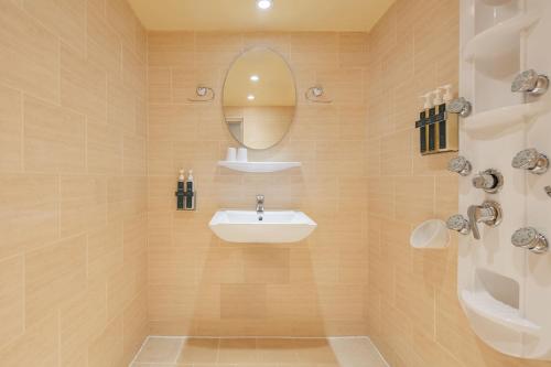 a bathroom with a sink and a mirror at Kindness Hotel - Wu Jia in Kaohsiung