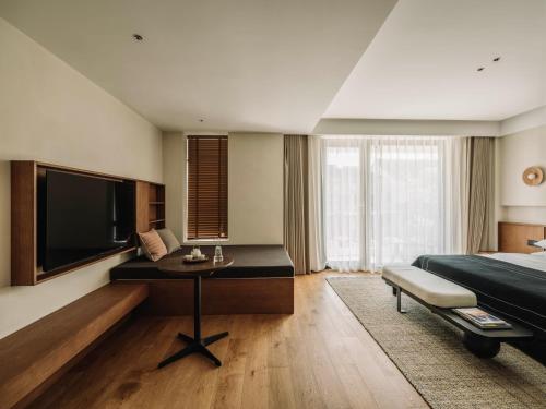 ein Hotelzimmer mit Bett und Fernseher in der Unterkunft Shine on in Kunshan