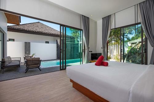 Un dormitorio con una cama y vistas a una piscina. en Thai Balinese Villa Rico in Kamala 3BR, Private Pool, en Kamala Beach