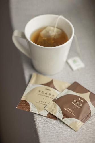 a cup of tea next to a cup of coffee at Kindness Hotel Wu-Jia in Kaohsiung