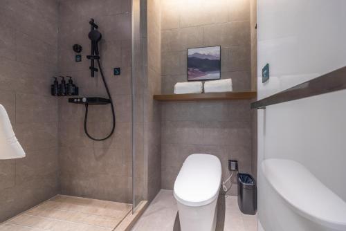 a bathroom with a shower and a toilet and a sink at Atour Hotel Hefei Huaihe Road Pedestrian Street City Hall Square in Hefei