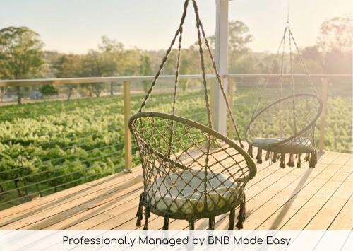 two chairs on a porch with a field of crops at Mortimer's Wines Loft - Adults Only Retreat in Orange
