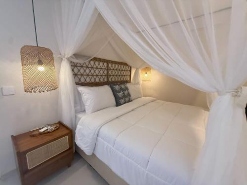 a bedroom with a white bed with a canopy at Villa KAS Legian Seminyak - 6 Bedroom Villa in Seminyak