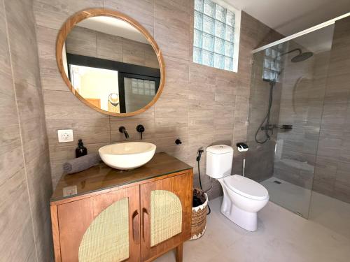 a bathroom with a sink and a toilet and a mirror at Villa KAS Legian Seminyak - 6 Bedroom Villa in Seminyak