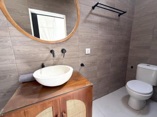 a bathroom with a sink and a mirror and a toilet at Villa KAS Legian Seminyak - 6 Bedroom Villa in Seminyak