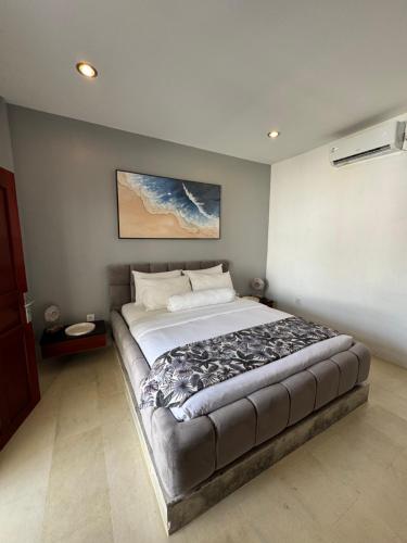 une chambre avec un grand lit dans une pièce dans l'établissement Uluwatu Stay's Standard Room #3, à Uluwatu