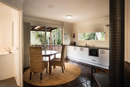 a kitchen with a table and chairs and a sink at Kondalilla Eco Resort in Montville