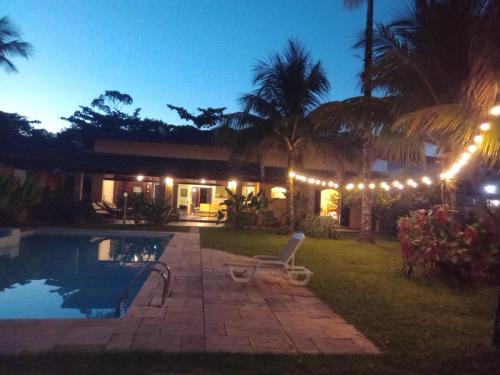 a house with a swimming pool at night with lights at Casa Praia Jardim Acapulco in Guarujá
