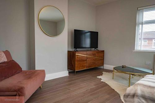 a living room with a tv and a mirror at Apartment near Blackpool Central & Pleasure Beach in Blackpool