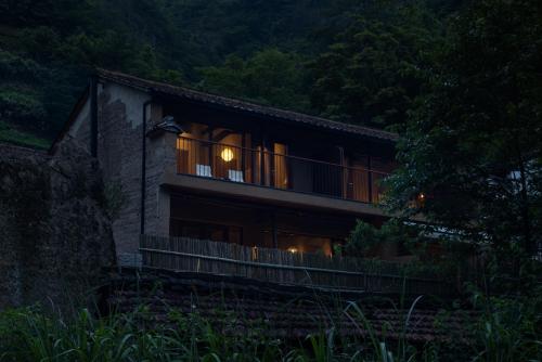 ein Haus in der Nacht mit eingeschaltetem Licht in der Unterkunft Jiuli Countryside Boutique resort in Xinchang