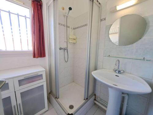 une salle de bain blanche avec un lavabo et une douche dans l'établissement Maison mitoyenne climatisée 7 pers. avec piscine et parking à Marseillan-Plage - FR-1-326-848, à Marseillan