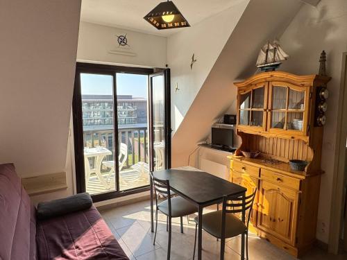 une chambre avec une table et une cuisine avec un balcon dans l'établissement Appartement 2 pièces accès direct plage, animaux acceptés, Wifi - FR-1-487-378, à Cabourg