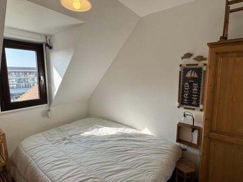 un lit dans une chambre avec une fenêtre dans l'établissement Appartement 2 pièces accès direct plage, animaux acceptés, Wifi - FR-1-487-378, à Cabourg