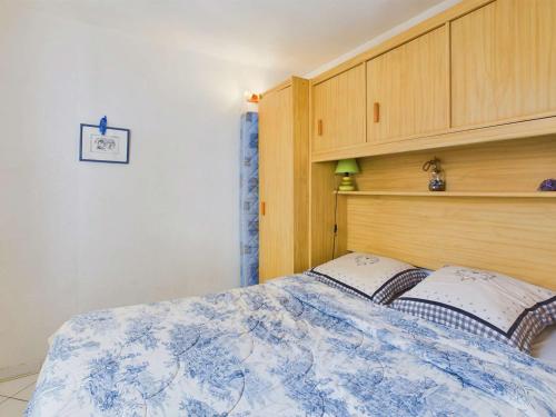 une chambre avec un lit avec une tête de lit en bois dans l'établissement Appartement 2 Pièces RDC avec Terrasse et Parking dans Résidence Sécurisée avec Piscine - FR-1-326-846, à Marseillan