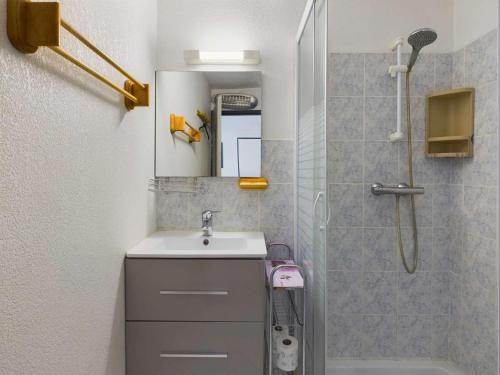 une salle de bain avec un lavabo et une douche avec un miroir dans l'établissement Appartement 2 Pièces RDC avec Terrasse et Parking dans Résidence Sécurisée avec Piscine - FR-1-326-846, à Marseillan