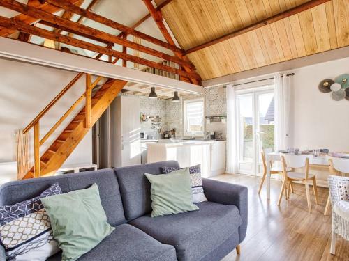 un salon avec un canapé bleu et une cuisine dans l'établissement Chalet lumineux avec grand jardin et parking privé à Merville-Franceville-Plage - FR-1-788-55, à Merville-Franceville-Plage