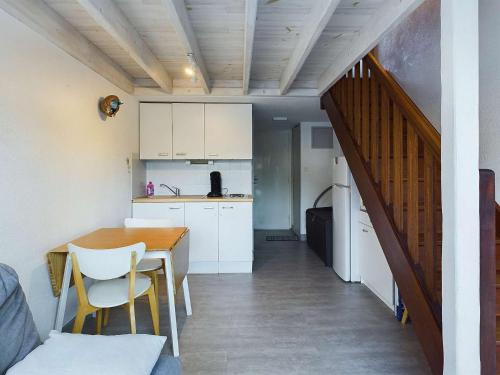 une cuisine et une salle à manger avec une table et un escalier dans l'établissement Appartement lumineux 2 pièces, terrasse, proche plage, parking, Grau D'Agde - FR-1-423-316, au Grau-dʼAgde