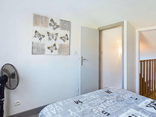 - une chambre avec un lit aux papillons sur le mur dans l'établissement Appartement lumineux 2 pièces, terrasse, proche plage, parking, Grau D'Agde - FR-1-423-316, au Grau-dʼAgde