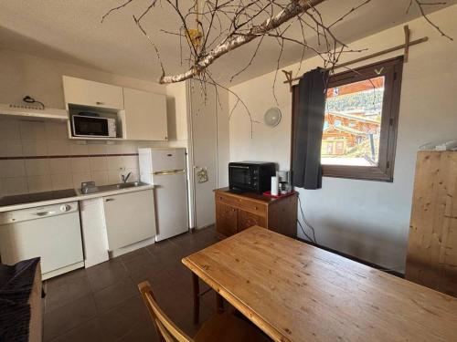 une cuisine avec une table en bois et un réfrigérateur dans l'établissement Bel appartement 3 pièces avec parking, Les Angles - FR-1-593-127, aux Angles