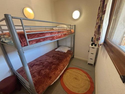 une chambre avec deux lits superposés et un tapis dans l'établissement Bel appartement 3 pièces avec parking, Les Angles - FR-1-593-127, aux Angles