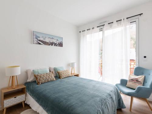 une chambre avec un lit et une chaise bleue dans l'établissement Grand Appartement Moderne, Proche Pistes, 8 Pers., Parking Inclus - FR-1-296-514, à Saint-Lary-Soulan