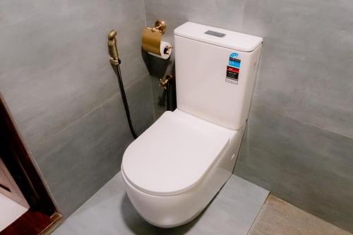 a toilet in a bathroom with a toilet paper dispenser at Hilltop villas in Mirissa