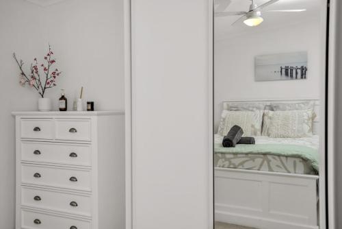 a bedroom with a closet with a bed and a dresser at Kingsford Cottage - WIFI, Pet Friendly in Victor Harbor