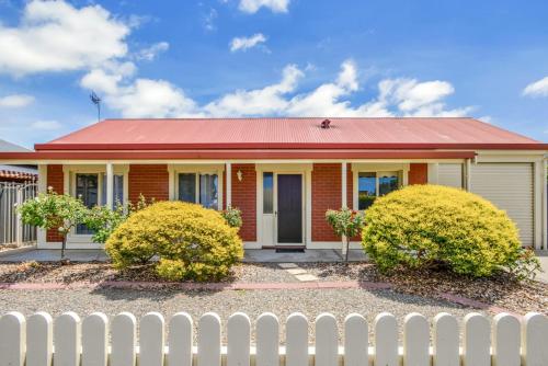 a red brick house with a white fence at Kingsford Cottage - WIFI, Pet Friendly in Victor Harbor