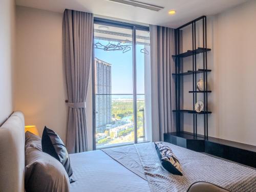 a bedroom with a bed and a large window at Ecopark Duplex Homestay by QMP in HÆ°ng YÃªn