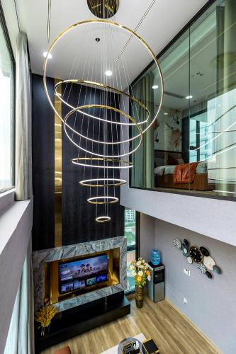 a living room with a fireplace and a chandelier at Ecopark Duplex Homestay by QMP in HÆ°ng YÃªn