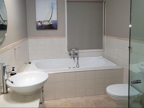 a bathroom with a tub and a toilet and a sink at The Manse in Queenscliff