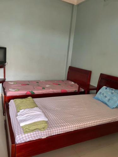 two beds sitting next to each other in a room at Nhà Nghỉ Hoa Cúc Xanh Lừa Đảo in Hue