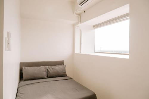 a bed in a room with a window at Tranquility in the City in Iloilo City