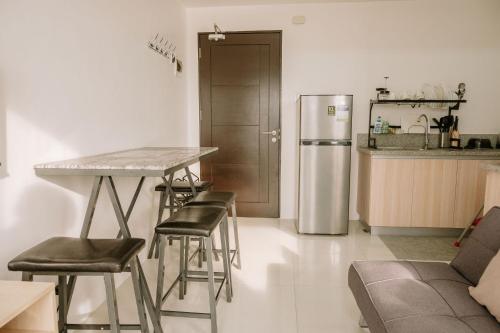 a kitchen with a table and chairs and a refrigerator at Tranquility in the City in Iloilo City