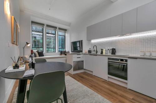 a kitchen and living room with a table and chairs at Historic Modern Luxury 1-Bedroom on Queen Street in Auckland