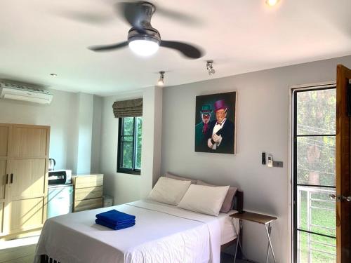 a bedroom with a white bed and a ceiling fan at Penthouse Crystal Bay Apartments in Ban Lamai