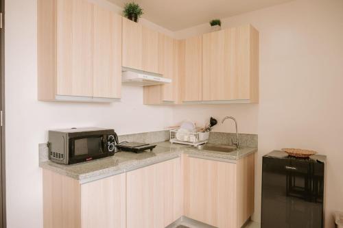 a kitchen with wooden cabinets and a microwave at A Simple Cozy Retreat in Iloilo City