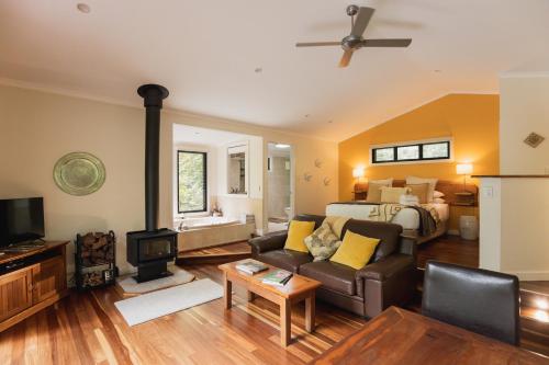 a living room with a couch and a bed at Kondalilla Eco Resort in Montville