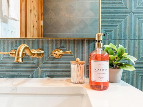 a bottle of alcohol sitting on a sink next to a faucet at Sunday House at The Sanctuary in Fredericksburg
