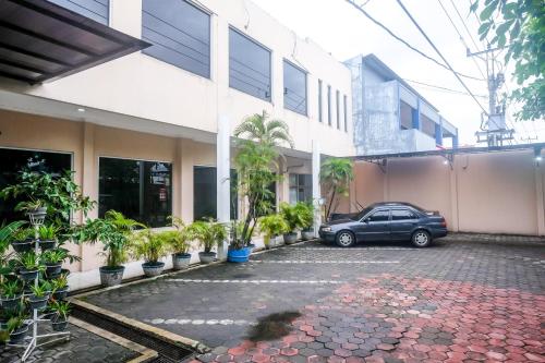 a car parked in a parking lot next to a building at RedDoorz Syariah at Griya Raharja Klaten in Klaten